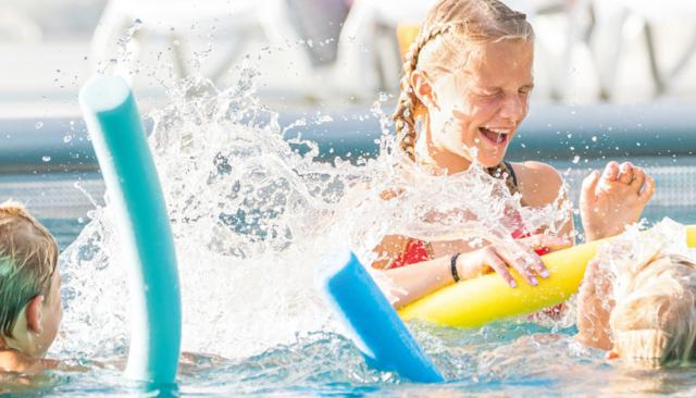 Kinder haben Spaß im Schwimmbecken