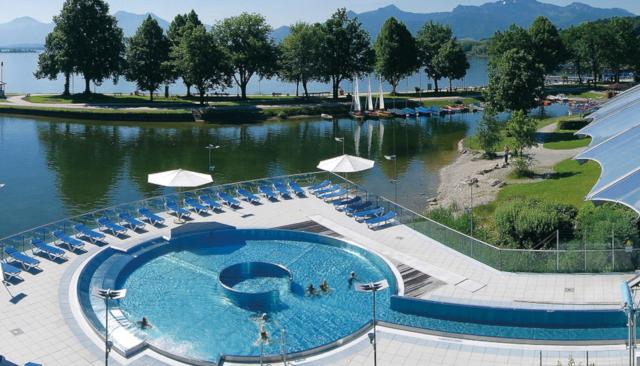 Luftbild vom Außenbecken mit dem Chiemsee im Hintergrund